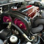 A modified motor running under the hood of a sports car.